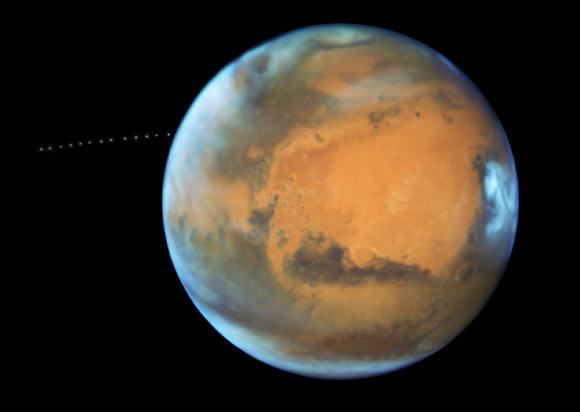 On May 12, 2016, Hubble took 13 separate exposures, allowing astronomers to create a time-lapse image showing Phobos during its orbital trek around Mars. This image is a composite of separate exposures acquired by NASA’s Hubble WFC3/UVIS instrument. Image credit: NASA / ESA / Z. Levay, STScI / J. Bell, ASU / M. Wolff, Space Science Institute.