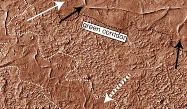 Aeolis Dorsa, Mars: the dotted white arrow points to curved strata recording point bar growth and river migration; the boundaries of ancient valley walls are defined by textural and albedo changes and are also associated with lateral river migration; stacked above the point bars and completely confined within the dotted white and black lines are topographically inverted river deposits outcropping as ridges (e.g., black arrow); in places (e.g., south of the dotted white arrow), the ridges run against the dotted boundaries, suggesting flow was once redirected along a valley wall. Image credit: Cardenas et al, doi: 10.1130/B31567.1.