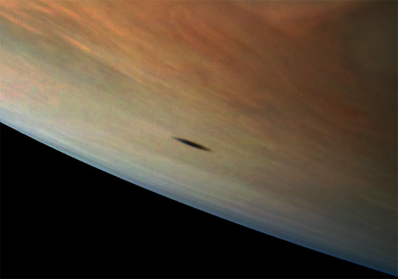 Amalthea casts a shadow on Jupiter in this image captured by NASA’s Juno spacecraft; the elongated shape of the shadow is a result of both the location of Amalthea with relation to Jupiter in this image as well as the irregular shape of the small moon itself. Image credit: NASA / JPL-Caltech / SwRI / MSSS / Gerald Eichstaedt.