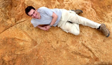Dr. Knoll lies next to the exceptionally large carnivorous dinosaur footprints found in Lesotho. Image credit: Fabien Knoll.