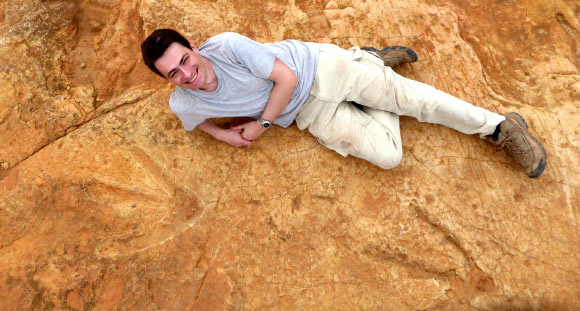 Dr. Knoll lies next to the exceptionally large carnivorous dinosaur footprints found in Lesotho. Image credit: Fabien Knoll.