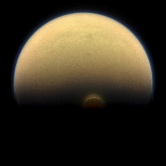 Titan’s south polar vortex stands out against the orange and blue haze layers that are characteristic of the hazy moon’s atmosphere. This view looks towards the trailing hemisphere of Titan (3,200 miles, or 5,150 km across). North on Titan is up and rotated 17 degrees to the left. Images taken using red, green and blue spectral filters were combined to create this natural-color view. The image was taken with the Cassini spacecraft narrow-angle camera on July 30, 2013. The view was acquired at a distance of approximately 895,000 miles (1.441 million km) from Titan. Image credit: NASA / JPL-Caltech / Space Science Institute.