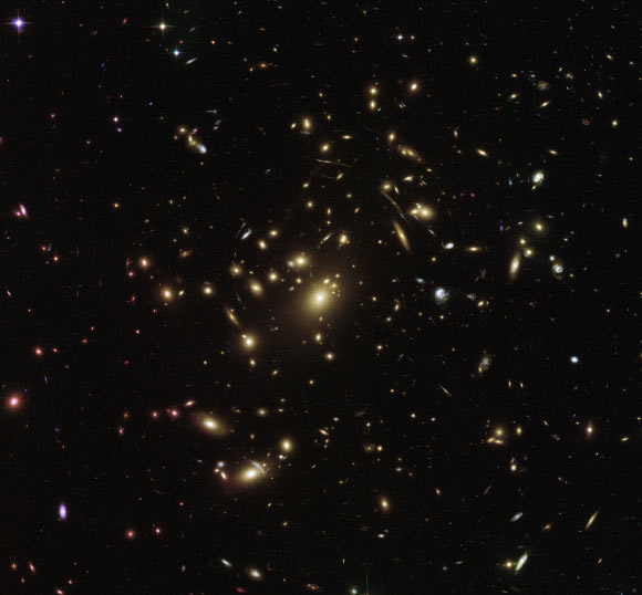 This Hubble image shows the galaxy cluster Abell 2537. The image is a composite of separate exposures acquired by Hubble’s ACS and WFC3 instruments. Five filters were used to sample various wavelengths. The color results from assigning different hues to each monochromatic image associated with an individual filter. Image credit: NASA / ESA / Hubble.