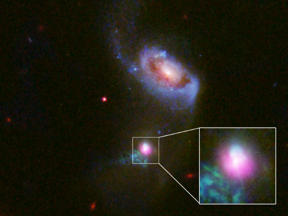 This image shows the SDSS J1354+1327 galaxy in a composite image with data from Chandra (purple), and Hubble (red, green and blue). The inset box contains a close-up view of the central region around SDSS J1354+1327’s supermassive black hole. The larger companion galaxy, SDSS J1354+1328, is shown to the north. Image credit: NASA / CXC / University of Colorado / STScI/ J. Comerford et al.
