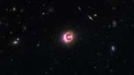 Image of the gravitational lens RX J1131-1231, with the foreground elliptical galaxy at the center and four images of the lensed quasar. It is estimated that there are trillions of planets in the lens galaxy. Image credit: University of Oklahoma.
