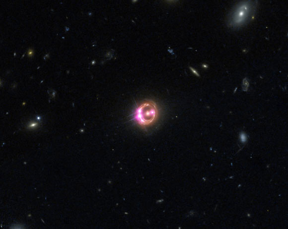 Image of the gravitational lens RX J1131-1231, with the foreground elliptical galaxy at the center and four images of the lensed quasar. It is estimated that there are trillions of planets in the lens galaxy. Image credit: University of Oklahoma.