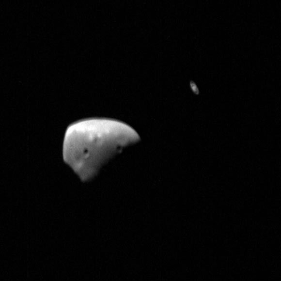 This image of Deimos and Saturn was taken by the Super Resolution Channel of Mars Express’ High Resolution Stereo Camera. In the foreground is the partially lit Deimos; in the background Saturn is visible, recognisable by its rings. This image was taken during Mars Express orbit 17, 770 on January 15, 2018. Image credit: ESA / DLR / FU Berlin / CC BY-SA 3.0 IGO.