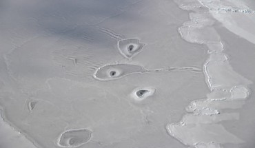 This image shows curious holes in Arctic sea ice, located about 50 miles (80.5 km) northwest of Canada’s Mackenzie River Delta. Image credit: John Sonntag / NASA’s Operation IceBridge Mission.