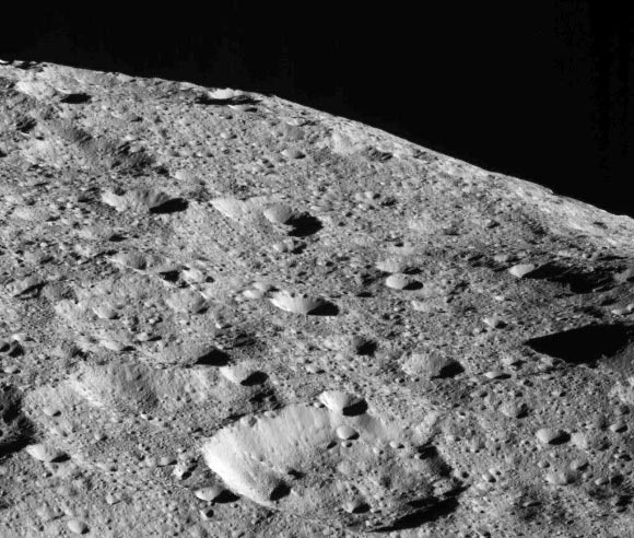 On the way to its lowest-ever and final orbit, Dawn is observing Ceres and returning new compositional data (infrared spectra) and images of the dwarf planet’s surface, such as this dramatic image of Ceres’ limb. This picture is one of the first images returned by Dawn in more than a year. The spacecraft captured this view on May 16, 2018 from an altitude of about 270 miles (440 km). The large crater near the horizon is about 22 miles (35 km) in diameter. It is located at about 23 degrees north latitude, 350 degrees east longitude, not far from a series of tholi (small mountains) that include Kwanzaa Tholus. The midsize crater in the foreground is located about 75 miles (120 km) from the large crater. This rough landscape suggests these features are on top of ancient terrains. Image credit: NASA / JPL-Caltech / UCLA / MPS / DLR / IDA.