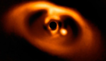 This image from the SPHERE instrument on ESO’s Very Large Telescope is the first clear image of an exoplanet caught in the very act of formation. The planet stands clearly out, visible as a bright point to the right of the center of the image, which is blacked out by the coronagraph mask used to block the blinding light of the central star. Image credit: ESO / A. Müller et al.