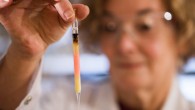 Biogeochemist Dr. Janet Hope holds an ampoule with pink colored porphyrins. Image credit: Australian National University.
