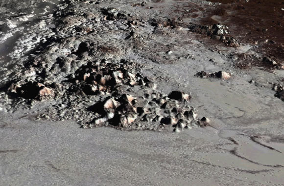 Perspective view of Pluto’s highest mountains, Tenzing Montes, along the western margins of Sputnik Planitia. Image credit: Paul Schenk, Lunar and Planetary Institute.