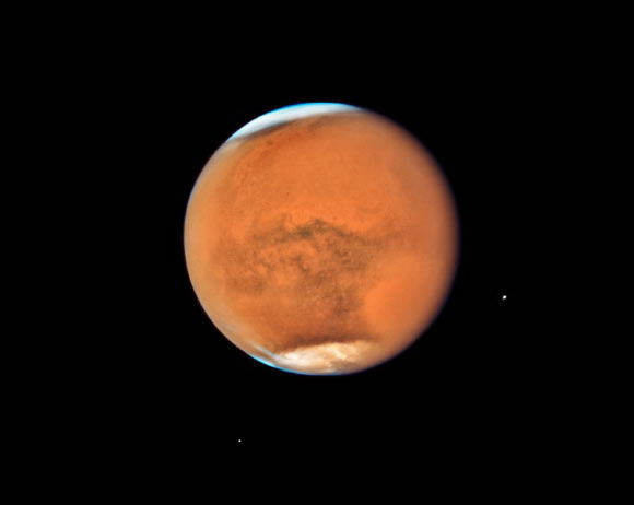 In mid-July Hubble observed Mars, only 13 days before the planet made its closest approach to Earth in 2018. While previous images showed detailed surface features of the planet, this new image is dominated by a gigantic sandstorm enshrouding the entire planet. Each Martian year, moderately large dust storms cover continent-sized areas and last for weeks at a time. Global dust storms tend to happen during the spring and summer in the southern hemisphere, when Mars is closest to the Sun and heating is at a maximum, leading to greater generation of winds. While spacecraft orbiting Mars can study the storm’s behaviour at lower altitudes, Hubble observations allow astronomers to study changes in the higher atmosphere. The combined observations will help planetary scientists to build a better understanding of how these global storms arise. Image credit: NASA / ESA / STScI.