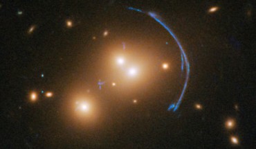 Acting as a ‘natural telescope’ in space, the gravity of SDSS J1152+3313 magnifies, brightens, and distorts a distant starburst galaxy. Image credit: NASA / ESA / Hubble / Judy Schmidt, www.geckzilla.com.