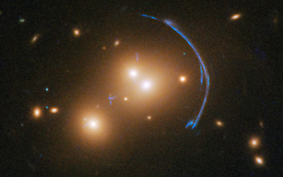 Acting as a ‘natural telescope’ in space, the gravity of SDSS J1152+3313 magnifies, brightens, and distorts a distant starburst galaxy. Image credit: NASA / ESA / Hubble / Judy Schmidt, www.geckzilla.com.