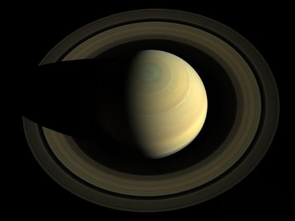 A swing high above Saturn by NASA’s Cassini spacecraft revealed this view of the golden-hued planet and its main rings. The view is in natural color, as human eyes would have seen it. This mosaic was made from 36 images in three color filters obtained by Cassini’s imaging science subsystem on October 10, 2013. Saturn sports differently colored bands of weather in this image. For instance, a bright, narrow wave of clouds around 42 degrees north latitude appears to be some of the turbulent aftermath of a giant storm that reached its violent peak in early 2011. The mysterious six-sided weather pattern known as the hexagon is visible around Saturn’s north pole. Image credit: NASA / JPL-Caltech / SSI / Cornell University.