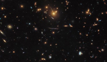 This Hubble image shows a massive group of galaxies bound together by gravity -- a galaxy cluster named SDSS J1050+0017. Image credit: NASA / ESA / Hubble / Judy Schmidt, www.geckzilla.com.