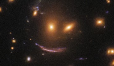 SDSS J0952+3434’s gravity magnifies and distorts a very distant galaxy, which is approximately 11 billion light-years away. Image credit: NASA / ESA / Hubble / Judy Schmidt, www.geckzilla.com.