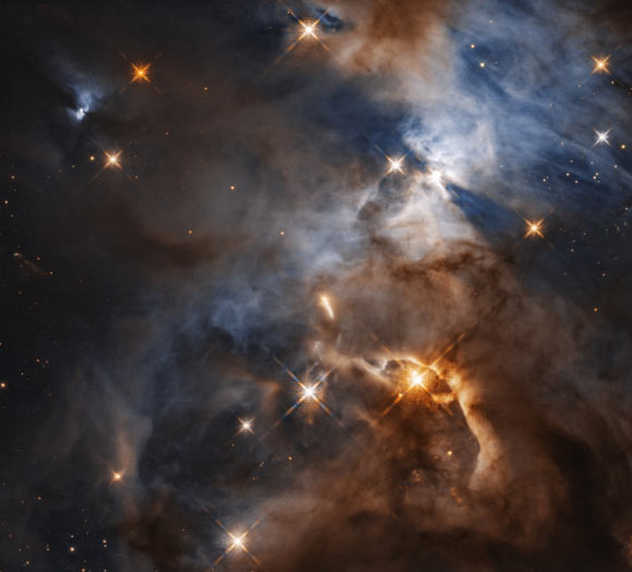 This Hubble image shows the Serpens Nebula, a stellar nursery about 1,300 light-years away. Within the nebula, in the upper right of the image, a shadow is created by the protoplanetary disk surrounding HBC 672. While the disk of debris is too tiny to be seen even by Hubble, its shadow is projected upon the cloud in which it was born. In this view, the feature, the Bat Shadow, spans approximately 200 times the diameter of our own Solar System. Image credit: NASA / ESA / STScI.