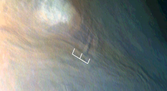 Three waves can be seen in this image, which is an excerpt of a JunoCam image taken on February 2, 2017, during Juno’s fourth flyby of Jupiter. The region imaged in this picture is part of the visibly dark band just north of Jupiter’s equator known as the North Equatorial Belt. Most of this belt is characterized by downwelling motions, but during the fourth flyby it had several bright areas of upwelling clouds. One of those upwelling clouds appears to be accompanied by dark regions, which are most likely shadows. The shadow associated with the center of the three waves is about 25 miles (40 km) long; from the angle of illumination, researchers deduced that the shadowed part of the wave must be around 4 miles (7 km) above the main cloud deck, with the peak of the wave probably close to 6 miles (10 km) above the main cloud deck. Image credit: NASA / JPL-Caltech / SwRI / MSSS / JunoCam.