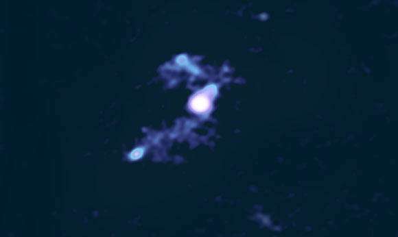 This image, created using ALMA data, shows W2246-0526 as it syphons material away from three smaller galaxies; W2246-0526 and one of its companions are in the center, the second galaxy is above them and the third is to the lower left. Image credit: ALMA / ESO / NAOJ / NRAO / S. Dagnello / AUI / NSF.