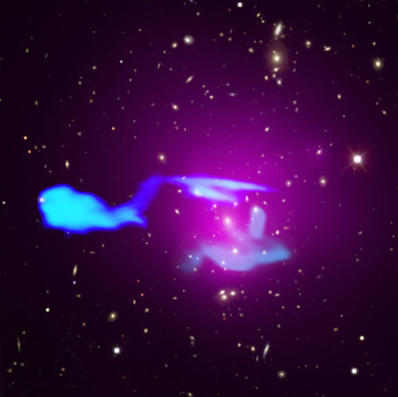 This composite image shows Abell 1033, two merging galaxy clusters located about 1.6 billion light-years from Earth. Image credit: X-ray – NASA / CXC / Leiden University / F. de Gasperin et al; optical – SDSS; radio – LOFAR / ASTRON / NCRA / TIFR / GMRT.