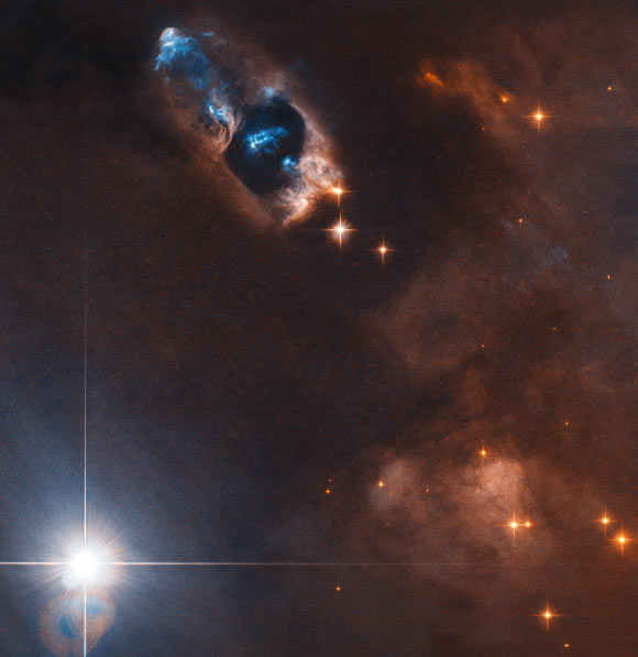 This image from the NASA/ESA Hubble Space Telescope shows the reflection nebula NGC 1333 and associated Herbig-Haro objects. The picture was snapped by Hubble’s Advanced Camera for Surveys (ACS). The image was made through two filters. The color results from assigning different hues to each monochromatic image associated with an individual filter. Image credit: NASA / ESA / Hubble / K. Stapelfeldt.