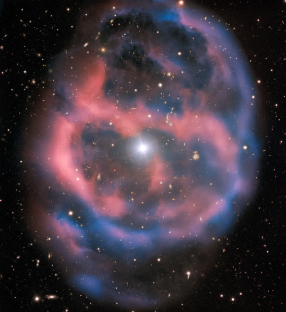 ESO 577-24 was imaged by the FOcal Reducer/low dispersion Spectrograph 2 (FORS2) on ESO’s Very Large Telescope. The FORS2 instrument captured the bright, central star, Abell 36, as well as the surrounding planetary nebula. The red and blue portions of this image correspond to optical emission at red and blue wavelengths, respectively. An object much closer to home is also visible in this image -- an asteroid wandering across the field of view has left a faint track below and to the left of the central star. And in the far distance behind the nebula a glittering host of background galaxies can be seen. Image credit: ESO.