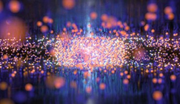 In conventional electronic devices, electricity requires the movement of electrons (blue spheres) and their positive counterparts, called holes (red spheres), which behave much like the gas molecules in our atmosphere. Although they move rapidly and collide infrequently in the gas phase, electrons and holes can condense into liquid droplets akin to liquid water in devices composed of ultrathin materials. Image credit: QMO Lab, University of California, Riverside.