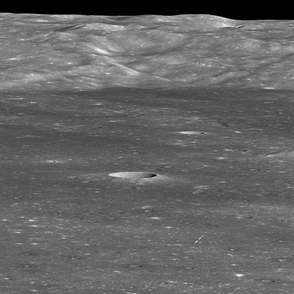 A January 30, 2019, image from NASA’s Lunar Reconnaissance Orbiter orbiting the Moon shows Chang’e 4 lander; arrows indicate position of the lander on the floor of Von Karman crater; the sharp crater behind and to the left of the landing site is 12,800 feet (3,900 m) across and 1,970 feet (600 m) deep. Image credit: NASA / GSFC / Arizona State University.