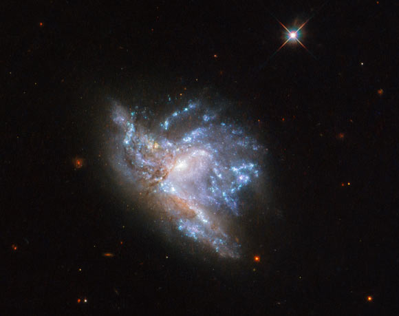This Hubble image shows two interacting galaxies, known collectively as NGC 6052. The picture was snapped by Hubble’s Wide Field Camera 3 (WFC3). Five filters were used to sample various wavelengths. The color results from assigning different hues to each monochromatic image associated with an individual filter. Image credit: NASA / ESA / Hubble / A. Adamo et al.