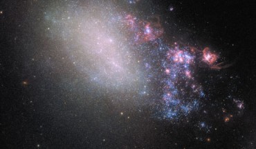This image of the irregular galaxy NGC 4485 was made from separate exposures taken in the visible region of the spectrum with Hubble’s Wide Field Camera 3 (WFC3) and Advanced Camera for Surveys (ACS). NGC 4485 has been involved in a dramatic gravitational interplay with its larger galactic neighbor, NGC 4490, out of frame to the bottom right in this image. This ruined the original, ordered spiral structure of the galaxy and transformed it into an irregular one. Below NGC 4485 one can see a bright, orange background galaxy: CXOU J123033.6+414057. This galaxy is the source of X-ray radiation studied by NASA’s Chandra X-ray Observatory. It’s distance from Earth is about 850 million light-years. Image credit: NASA / ESA / Hubble.
