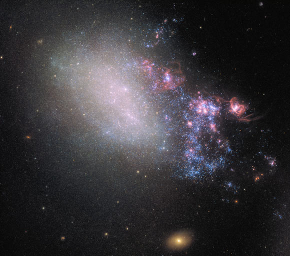 This image of the irregular galaxy NGC 4485 was made from separate exposures taken in the visible region of the spectrum with Hubble’s Wide Field Camera 3 (WFC3) and Advanced Camera for Surveys (ACS). NGC 4485 has been involved in a dramatic gravitational interplay with its larger galactic neighbor, NGC 4490, out of frame to the bottom right in this image. This ruined the original, ordered spiral structure of the galaxy and transformed it into an irregular one. Below NGC 4485 one can see a bright, orange background galaxy: CXOU J123033.6+414057. This galaxy is the source of X-ray radiation studied by NASA’s Chandra X-ray Observatory. It’s distance from Earth is about 850 million light-years. Image credit: NASA / ESA / Hubble.