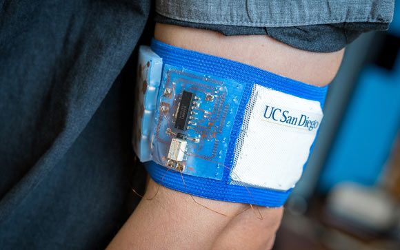 Prototype of the cooling and heating patch embedded in a mesh armband. Image credit: David Baillot / Jacobs School of Engineering, University of California, San Diego.