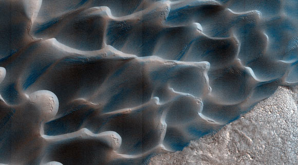 The retreat of the Martian polar cap of frozen carbon dioxide during the spring and summer generates winds that drive the largest movements of sand dunes observed on Mars. Image credit: NASA / JPL / University of Arizona / USGS.