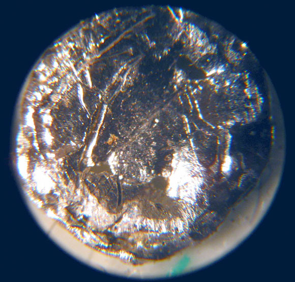 A small disk of americium-241 under the microscope. Image credit: Bionerd / CC BY 3.0.