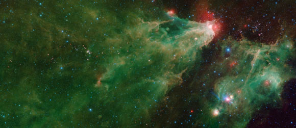 This Spitzer image shows the Cepheus C and Cepheus B regions. The image was compiled using data from Spitzer’s Infrared Array Camera (IRAC) and the Multiband Imaging Photometer (MIPS). The colors correspond with IRAC wavelengths of 3.6 microns (blue), 4.5 microns (cyan) and 8 microns (green), and 24 microns (red) from the MIPS instrument. Image credit: NASA / JPL-Caltech.