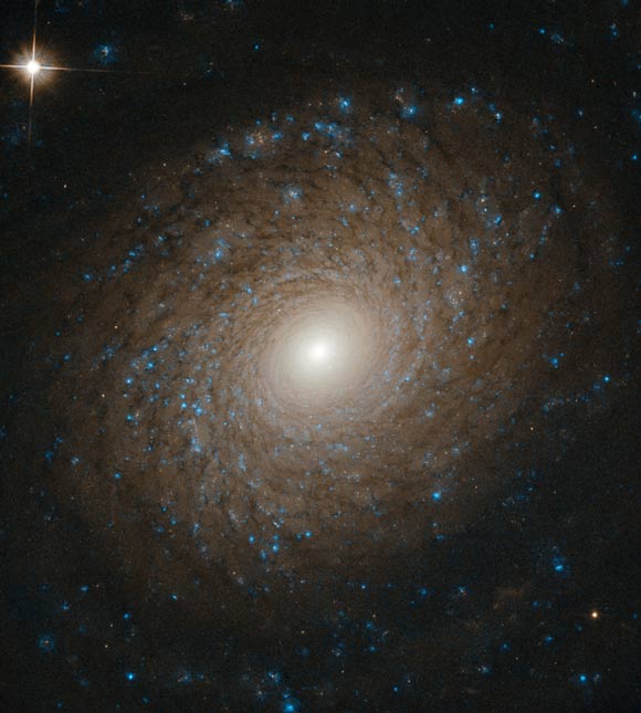 This Hubble image shows the multi-armed spiral galaxy NGC 2985. The color image was made from separate exposures taken in the visible and near-infrared regions of the spectrum with Hubble’s Advanced Camera for Surveys (ACS). It is based on data obtained through two filters: F658W and F814W. The color results from assigning different hues to each monochromatic image associated with an individual filter. Image credit: NASA / ESA / Hubble / L. Ho.