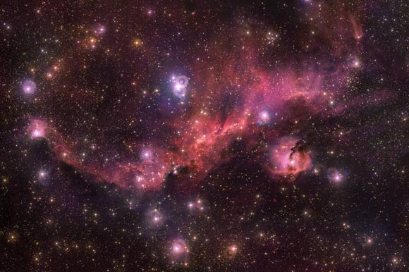 Colorful and wispy Sharpless 2-296 forms the ‘wings ‘ of an area of sky known as the Seagull Nebula -- named for its resemblance to a gull in flight. This celestial bird contains a fascinating mix of intriguing astronomical objects. Glowing clouds weave amid dark dust lanes and bright stars. The Seagull Nebula -- made up of dust, hydrogen, helium and traces of heavier elements -- is the hot and energetic birthplace of new stars. Image credit: ESO / VPHAS+ Team / N.J. Wright, Keele University.