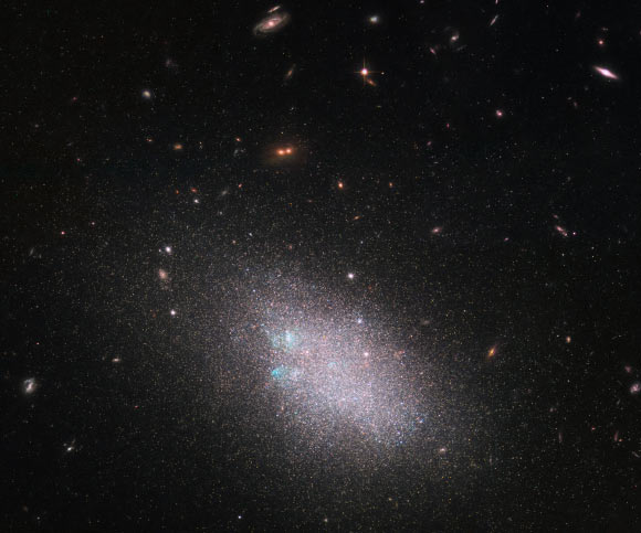 This Hubble image shows the dwarf galaxy UGC 685, which lies in the constellation of Pisces, 15.7 million light-years away. The color image was made from separate exposures taken in the visible and near-infrared regions of the spectrum with Hubble’s Wide Field Planetary Camera 2 (WFPC2) and Advanced Camera for Surveys (ACS). Three filters were used to sample various wavelengths. The color results from assigning different hues to each monochromatic image associated with an individual filter. Image credit: NASA / ESA / Hubble / LEGUS Team / B. Tully / D. Calzetti / Judy Schmidt, www.geckzilla.com.