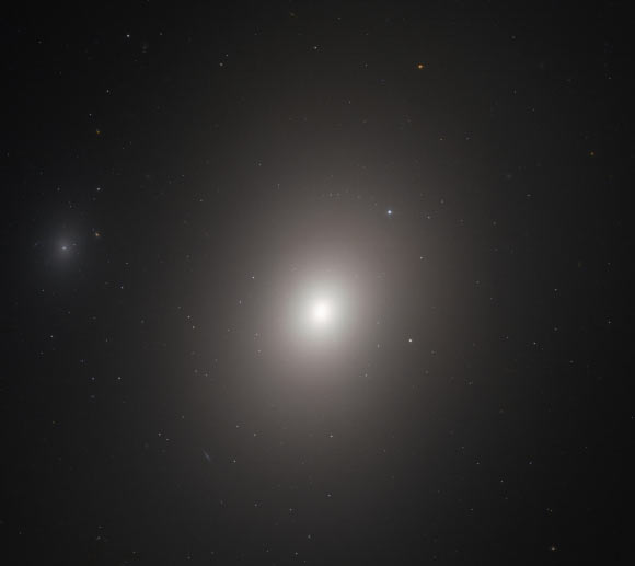 This Hubble image shows a galaxy called Messier 86. The image is made up of observations from Hubble’s Advanced Camera for Surveys (ACS) in the optical part of the spectrum. Two filters were used to sample various wavelengths. The color results from assigning different hues to each monochromatic image associated with an individual filter. Image credit: NASA / ESA / Hubble / P. Cote et al.