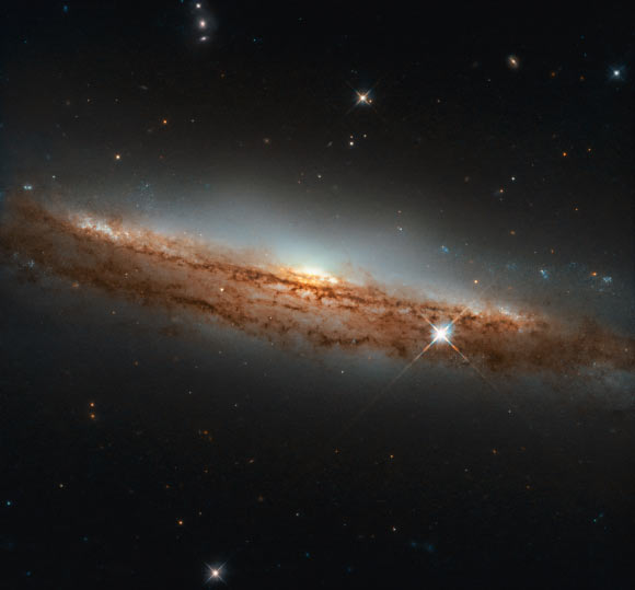 This Hubble image shows the edge-on spiral galaxy NGC 3717. The image is made up of observations from Hubble’s Wide Field Camera 3 (WFC3) in the infrared and optical parts of the spectrum. Two filters were used to sample various wavelengths. The color results from assigning different hues to each monochromatic image associated with an individual filter. Image credit: NASA / ESA / Hubble / D. Rosario.