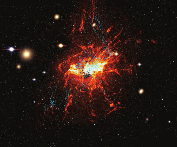 This Hubble image shows young globular clusters (blue) and filaments of cool gas (red) around NGC 1275 in the center of the Perseus cluster (also known as Abell 426), a group of over 1,000 galaxies located 240 million light-years from Earth. Image credit: Lim et al, doi: 10.1038/s41550-019-0909-6.