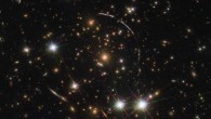 This Hubble image shows a massive galaxy cluster, about 4.6 billion light years away. Along its borders 12 images within the four arcs are visible; these are copies of the same galaxy called PSZ1 G311.65-18.48, which is almost 11 billion light-years away. Three of these arcs are visible in the top right of the image, while one counterarc is visible in the lower left -- partially obscured by a bright foreground star within our Milky Way Galaxy. Image credit: NASA / ESA / Hubble / Rivera-Thorsen et al.