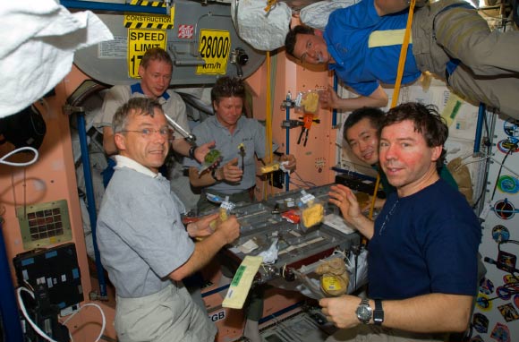 The Expedition 20 crew members share a meal in the Unity node of the International Space Station. Image credit: NASA.
