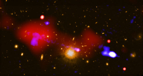 This composite image shows the surroundings of a supermassive black hole that is triggering star formation across the longest distance ever seen; as hot gas swirls around the black hole, it emits large amounts of X-rays that Chandra detects; the black hole is also the source of radio-wave emission from a jet of high-energy particles -- previously detected by scientists with the VLA -- that stretches about a million light-years. Image credit: NASA / CXC / INAF / R. Gilli et al / NRAO / VLA / STScI.