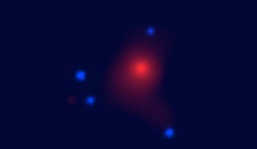 X-ray image of the gravitational lens system SDSS J1004+4112 taken by NASA’s Chandra X-ray Observatory; the central red extended emission is from the hot gas in the foreground lens galaxy cluster and the four blue point sources are the lensed images of the background quasar. Image credit: University of Oklahoma.