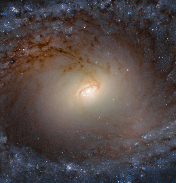 This Hubble image shows the central region of IC 2051, a spiral galaxy located 90 million light-years away in the constellation Mensa. The image is made up of observations from Hubble’s Wide Field Camera 3 (WFC3) in the optical and infrared parts of the spectrum. Three filters were used to sample various wavelengths. The color results from assigning different hues to each monochromatic image associated with an individual filter. Image credit: NASA / ESA / Hubble / P. Erwin et al.