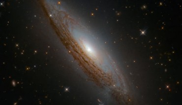 This Hubble image shows ESO 021-G004, a spiral galaxy located approximately 130 million light-years away in the constellation Chamaeleon. The color image was made from separate exposures taken in the visible and infrared regions of the spectrum with Hubble’s Wide Field Camera 3 (WFC3). Two filters were used to sample various wavelengths. The color results from assigning different hues to each monochromatic image associated with an individual filter. Image credit: NASA / ESA / Hubble / D. Rosario et al.
