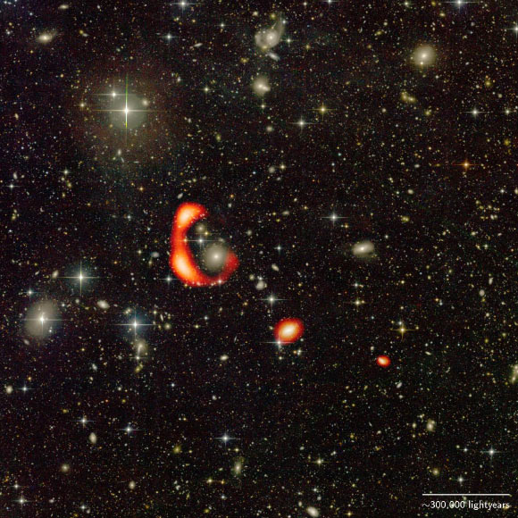 This CFHT image shows a huge ring of neutral hydrogen gas (red) around the galaxy AGC 203001. The two small red blobs show the distribution of neutral hydrogen around two other galaxies. Image credit: Omkar Bait, NCRA-TIFR & GMRT / Pierre-Alain Duc, ObAS & CFHT.